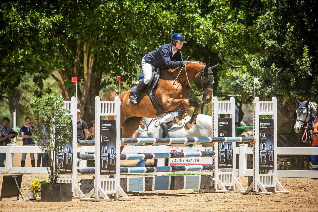 Show jumper clearing a fence in competition